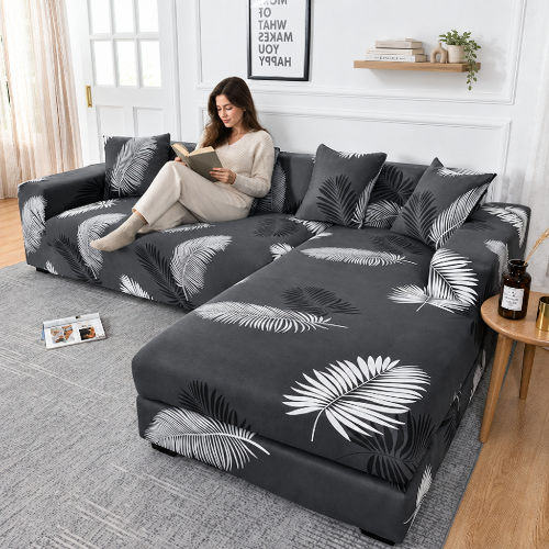 housse canape angle au fond gris avec feuillage blanc et noir avec une femme qui lit un livre