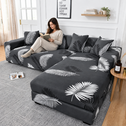 housse canape angle au fond gris avec feuillage blanc et noir avec une femme qui lit un livre