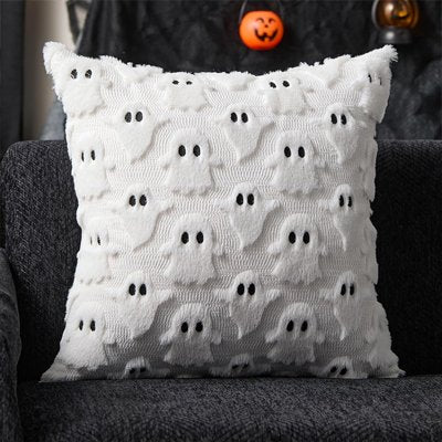 housses de coussin d'halloween dans les tons de blanc avec des fantômes en prohéminence sur un fauteuil gris