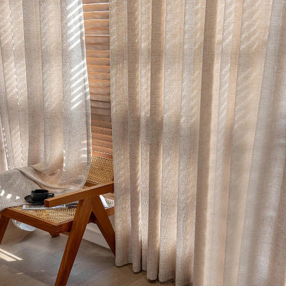 rideau dans les teintes de beige présenté sur une grand fenêtre lumineuse
