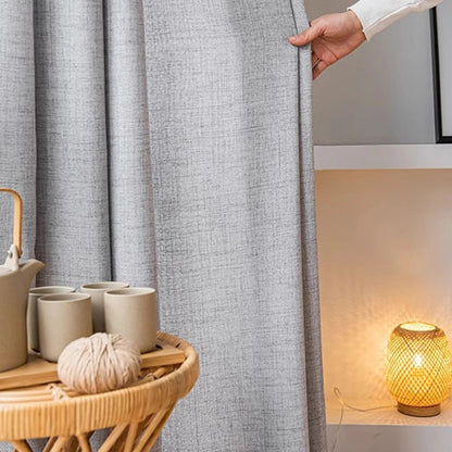 rideau style lin gris avec une main qui montre le tissu