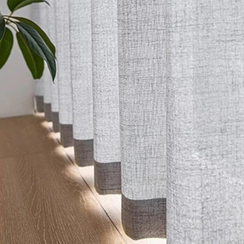 rideau au colori gris et au design lin avec vue sur la finition du bas près du plancher