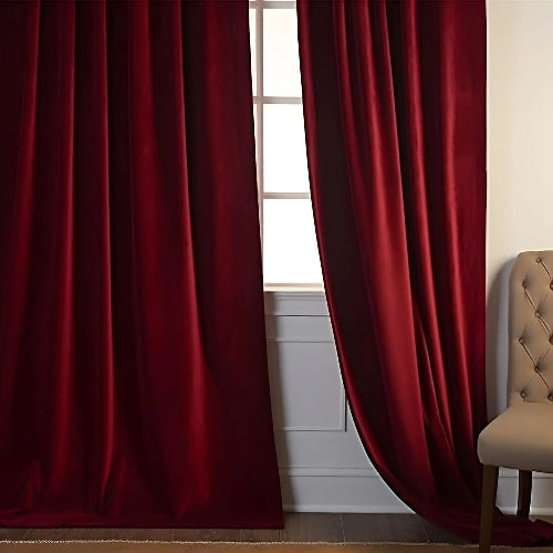 rideaux pour salon de couleur rouge velouté sur une fenêtre avec une chaise capitonnée à droite