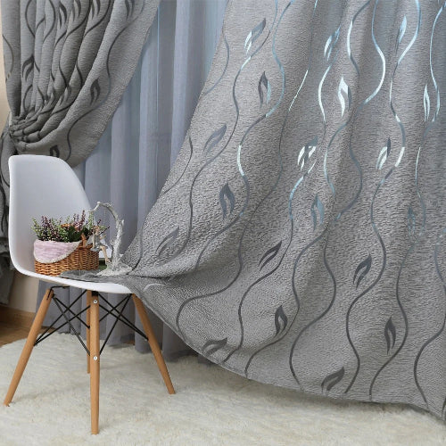 rideaux salon moderne dans les tons de gris avec un motif végétal tombant sur une chaise 